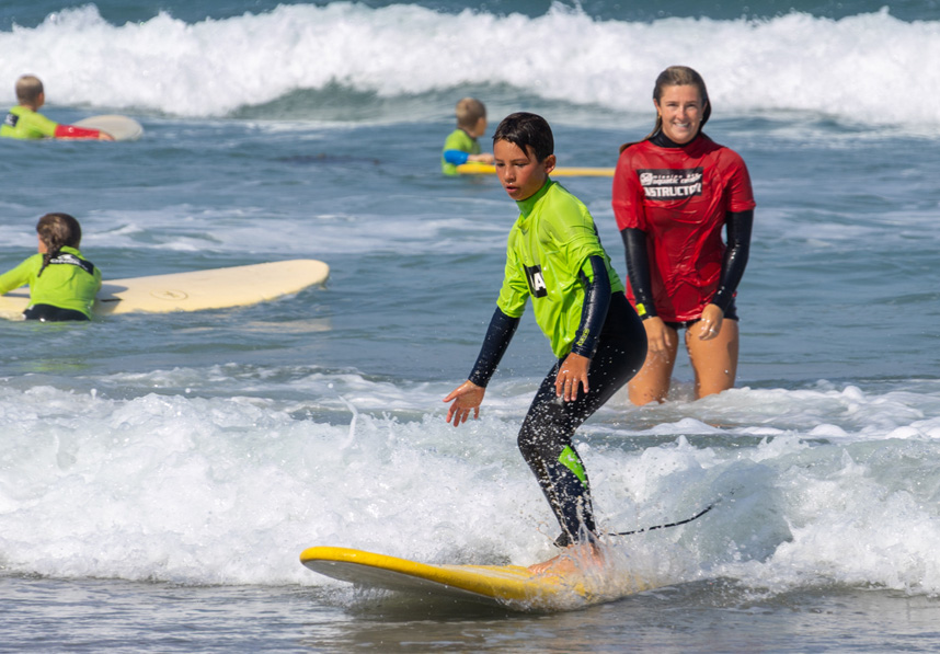 Kid surfing under supervision of counselor